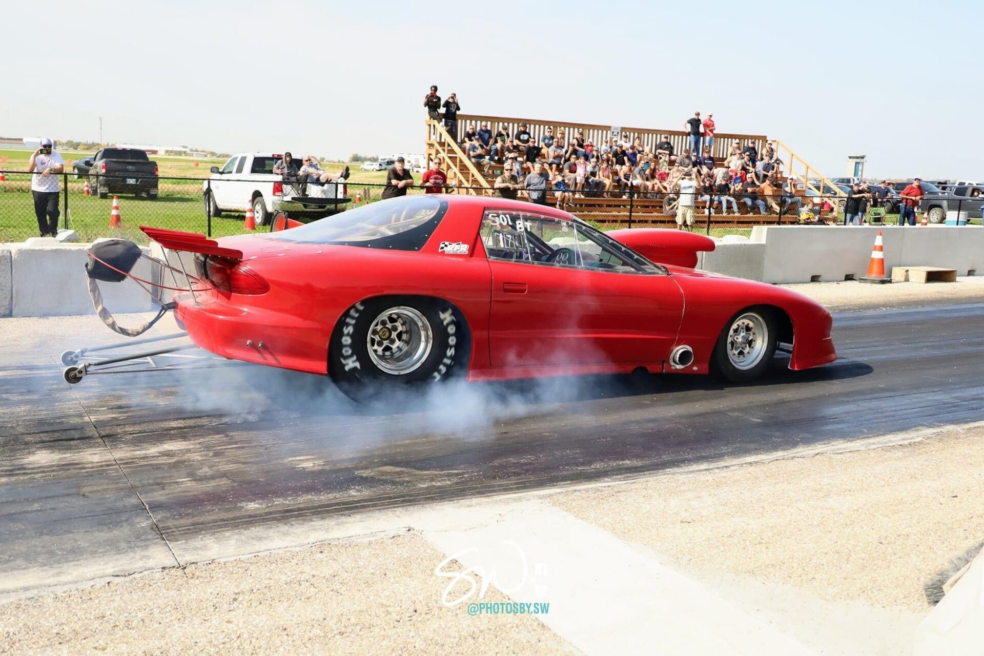 A red car speeding on a drag strip, showcasing its power and agility in a thrilling race.